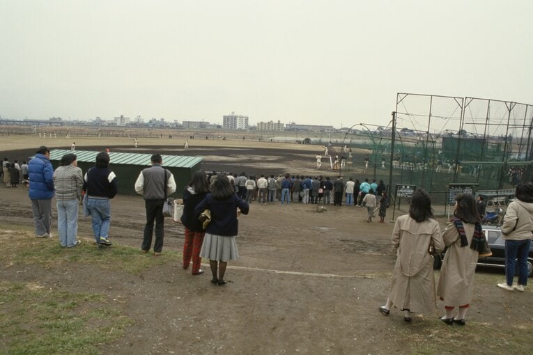 資料写真、1985年撮影の巨人軍多摩川グラウンド。当時、練習開始の午前10時には、熱心なファンが集まっていたという。女性ファンたちは“多摩川ギャル”と呼ばれた　©BUNGEISHUNJU