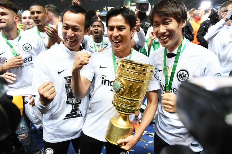 【長谷部誠、ドイツでの足跡】2018年、ドイツ杯を手に鎌田大地（右）や黒川孝一トレーナーと写真に収まる　©Etsuo Hara/Getty Images