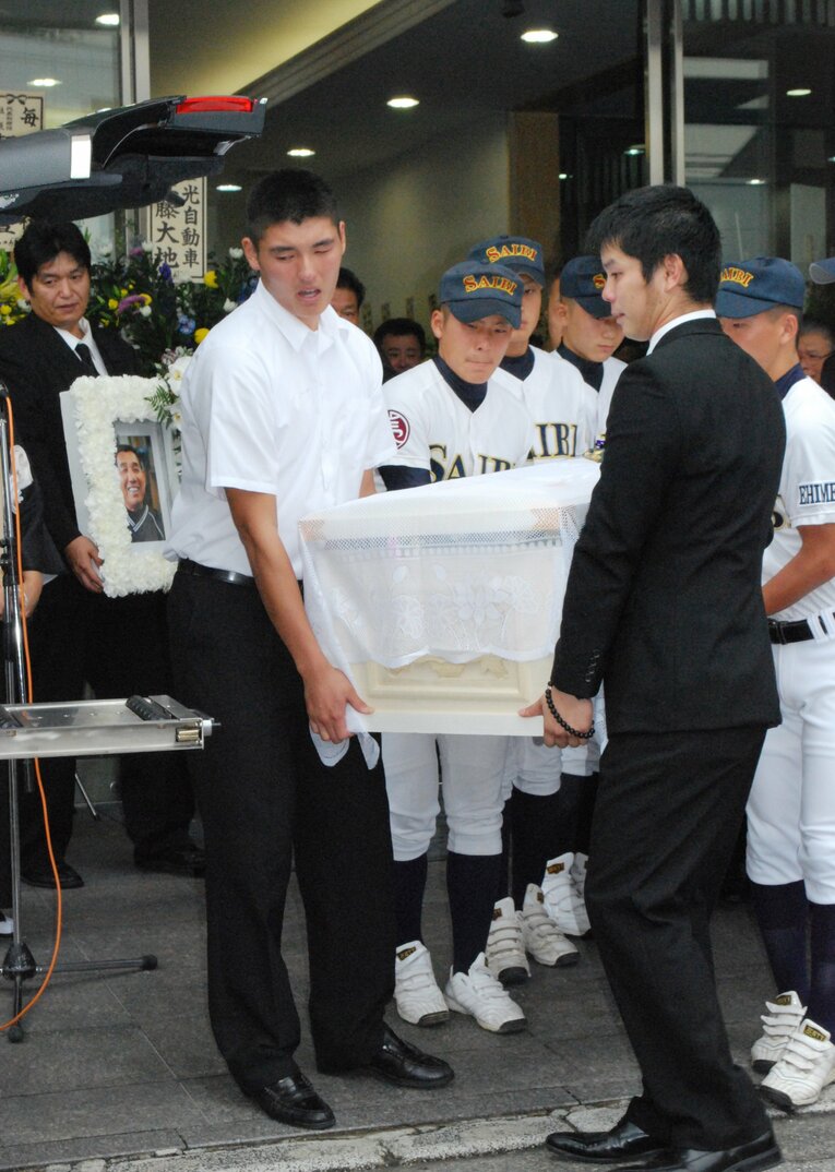 涙を流しながら棺を持つ安樂（左）　©JIJI PRESS