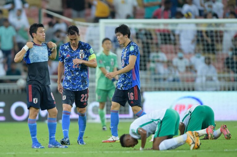 「6ポイントマッチ」に敗れてうなだれる吉田。一方、祈りを捧げるサウジの選手たち ／ photograph by Getty Images