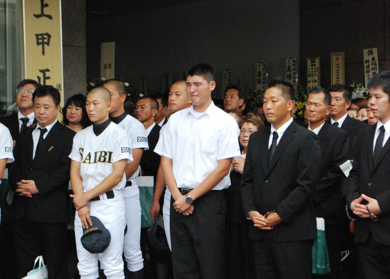 出棺の際、涙を浮かべる安樂（中央）　©JIJI PRESS