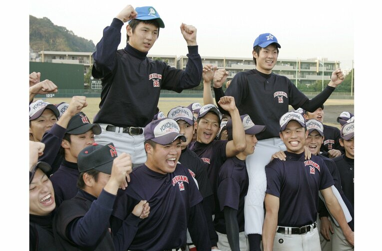 横浜高チームメートに祝福される西武1巡目指名の涌井秀章（左）と横浜6巡目指名の石川雄洋（2004年）　©KYODO