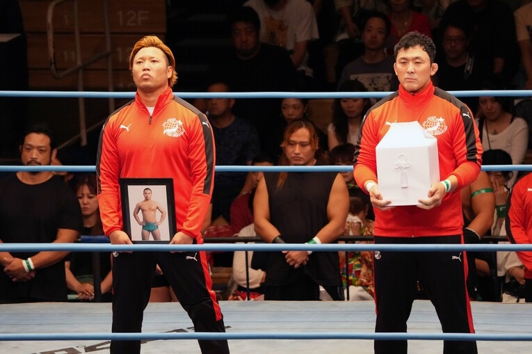 宮原健斗が遺影を持ち、鈴木秀樹が遺骨を抱いた長尾一大心選手の追悼セレモニー。9月15日、後楽園ホール　©Essei Hara