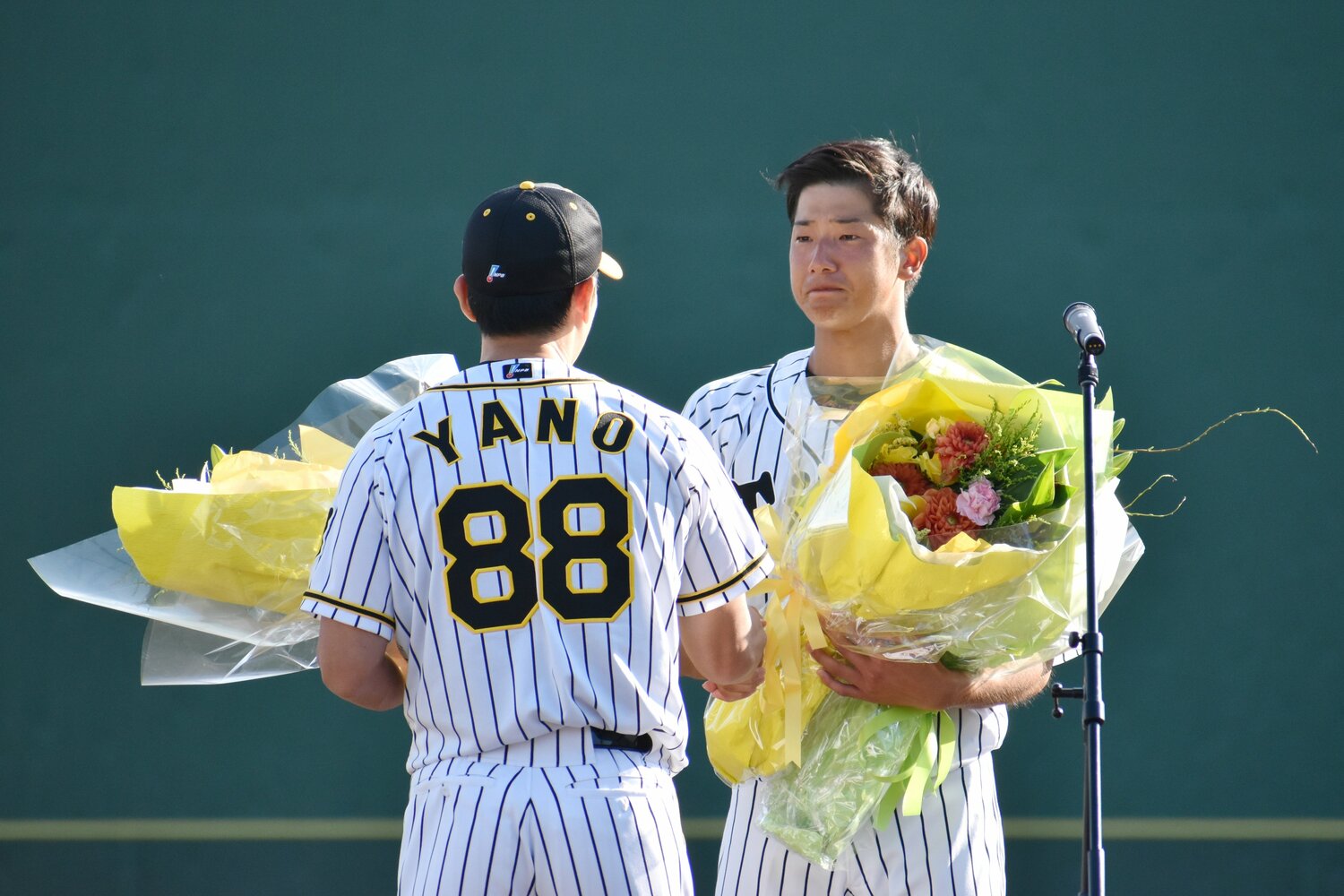 2019年９月、引退セレモニーで、矢野燿大監督（左）から花束を受け取る横田慎太郎さん（鳴尾浜球場）　©︎JIJI PRESS 