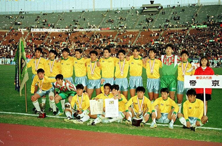 第70回全国高校サッカー選手権大会決勝で、四日市中央工との同時優勝を果たした帝京イレブン。後列左端の阿部敏之（元鹿島他）の隣にいるのが日比監督（1992年1月8日）