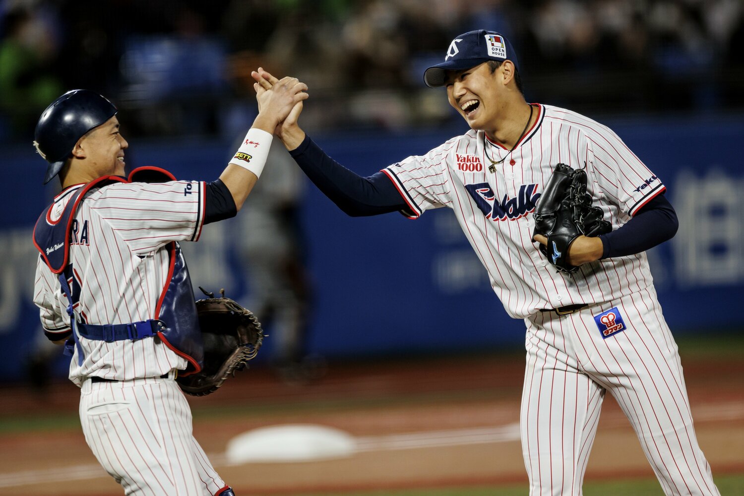 試合終了直後、中村悠平と笑顔でハイタッチする奥川　©Kiichi Matsumoto