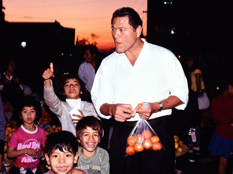 ペルー・リマの青空市場で買ったオレンジを頬ばる猪木。1991年7月　©Essei Hara