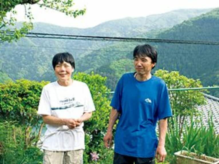 奥多摩湖を一望できる自宅の庭で、クライミングパートナーでもある奥様の妙子さんと。