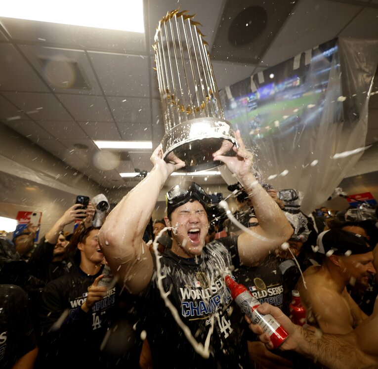 シャンパンファイトで優勝トロフィーを掲げる大谷翔平　©︎JIJI PRESS