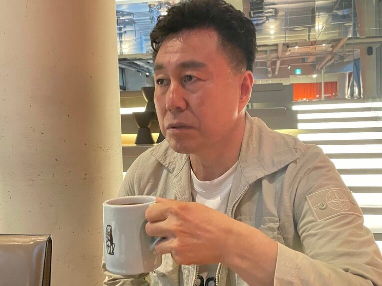 左手でカップを持ち、コーヒーをすする盧廷潤　©︎NumberWeb