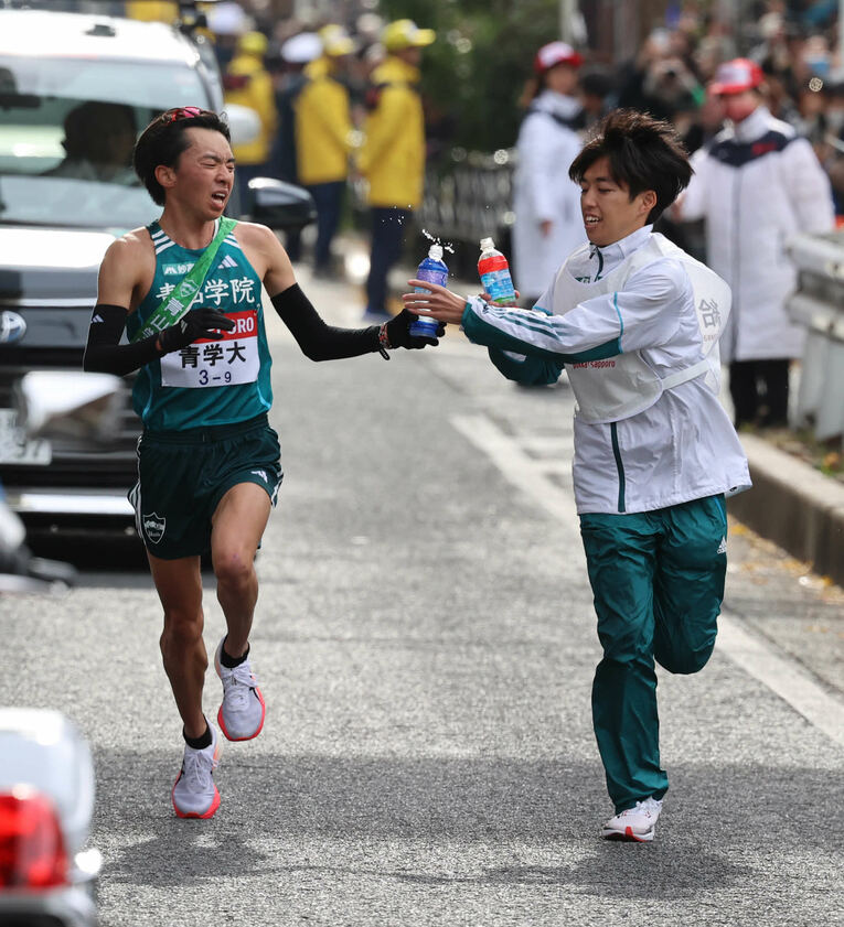 青学大9区の倉本玄斗（4年）に給水をするキャプテン・志貴勇斗　©Nikkan Sports／AFLO