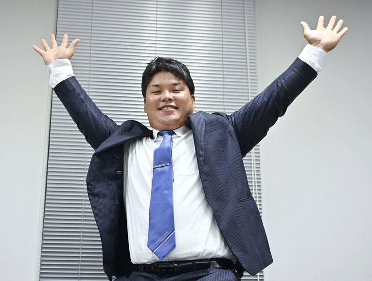 西武から1位指名を受け、記者会見でポーズをとる桐蔭横浜大の渡部健人　©KYODO