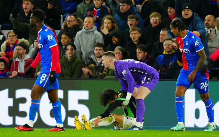 12月21日のクリスタルパレス戦。左足首を痛めた三笘薫。“ダイブ”と勘違いした敵GKディーン・ヘンダーソンが無理矢理起こすシーン　©AFLO