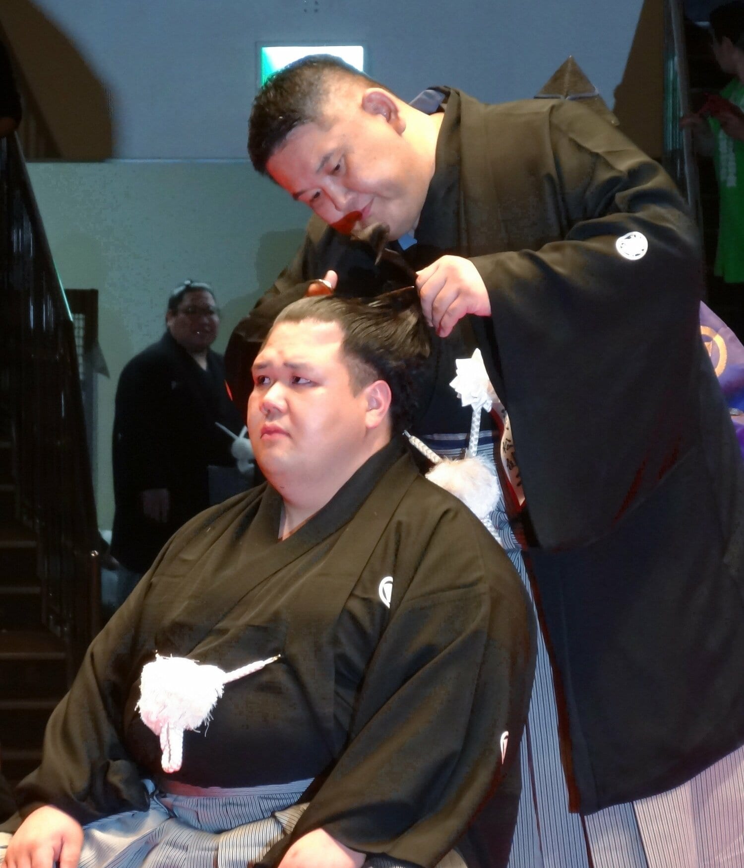 断髪式で師匠の阿武松親方（右）に大いちょうを切り落とされる元小結・阿武咲（2025年6月）　©︎JIJI PRESS