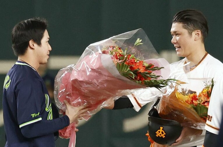 11月8日、2000本目の安打を放ち、ヤクルトの山田哲人から花束を受け取った巨人・坂本勇人 ／ photograph by KYODO