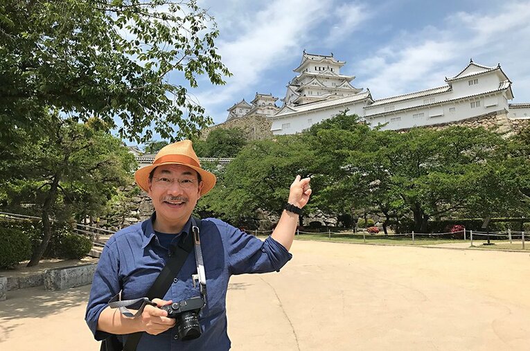 姫路城の前でポーズをとる千田嘉博教授。「中国大返しの新説」は旧兵庫城の発掘がきっかけだった。 ／ photograph by Yoshihiro Senda