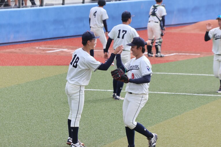 公式戦でチームメイトとハイタッチを交わす花園大の藤原聡大　©Fumi Sawai