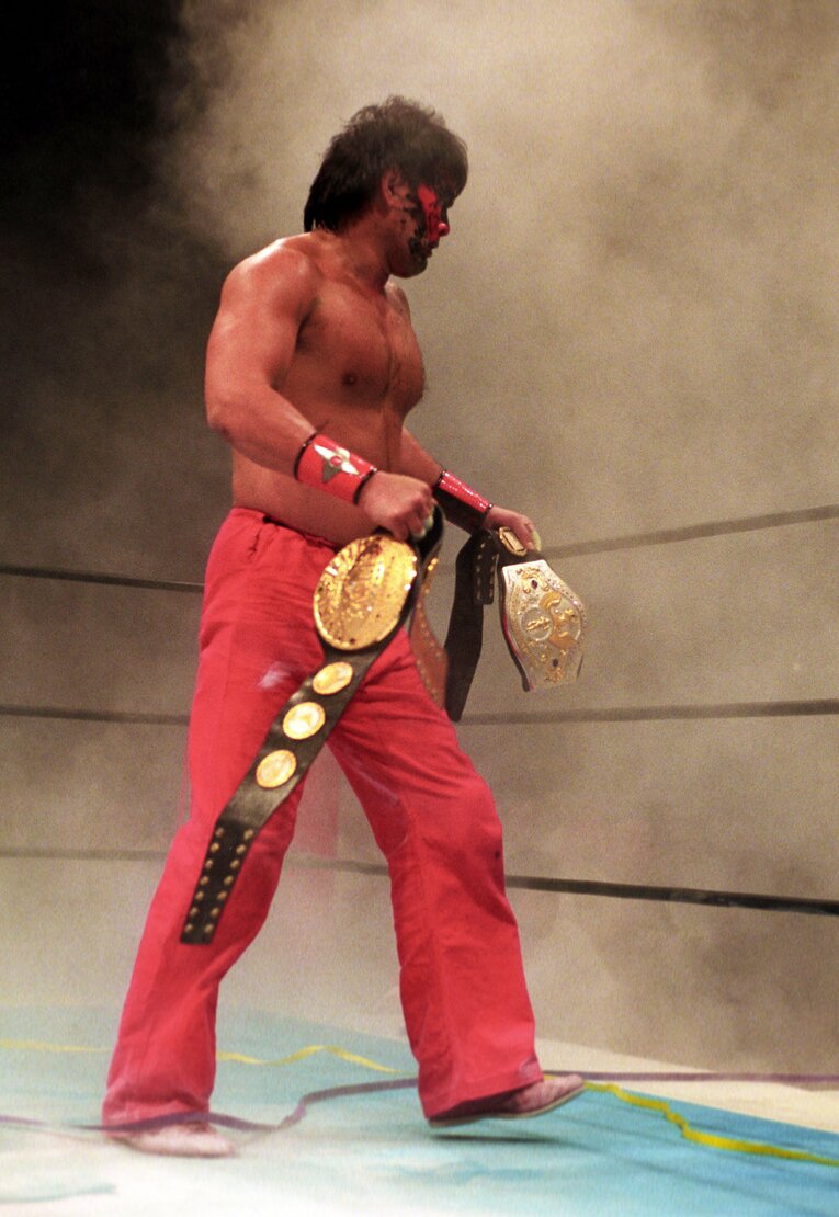 消火器を噴射し、IWGPとグレーテスト18クラブの2つのベルトを手に引き上げるムタ