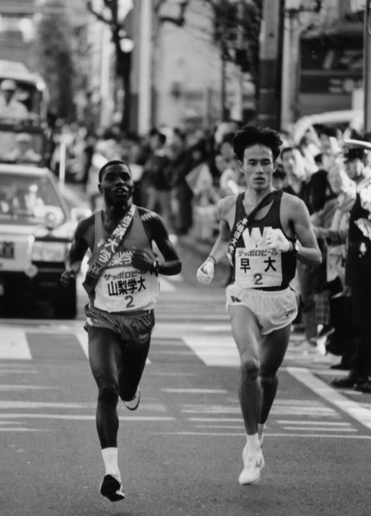 1994年大会、2区で山梨学院大・マヤカ（左）と併走する早大・花田勝彦。早大は前年に優勝、この大会は2位だった　©KYODO