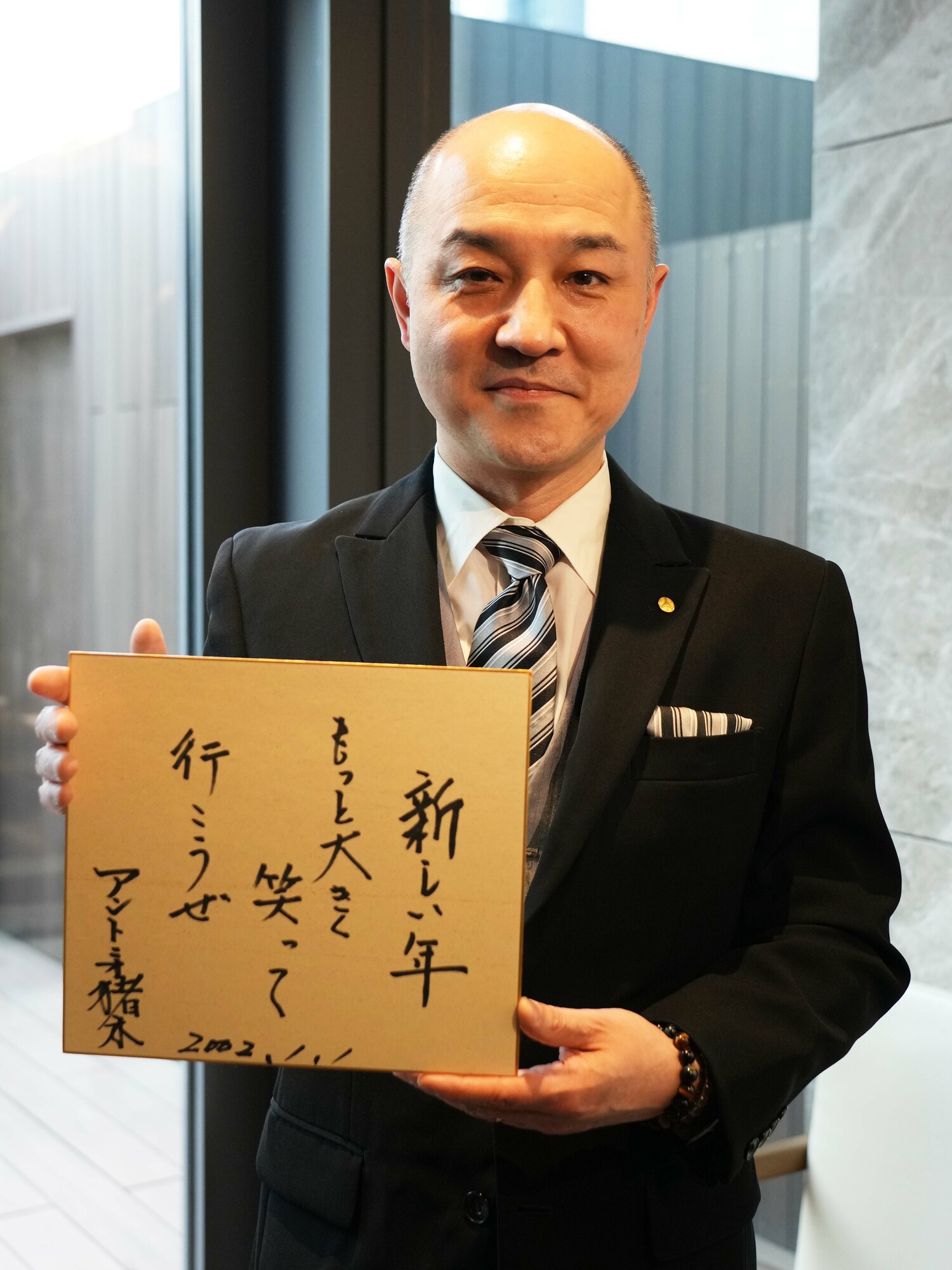 2002年に猪木が初めて書いた新年の色紙を手にする萩俊一さん