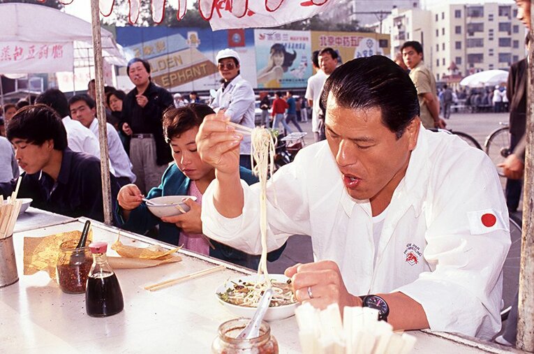 「日中友好プロレス大会」を初開催した1990年。朝のランニングの後、屋台に立ち寄って美味しい麺を地元の人達と一緒にすすった。 ／ photograph by Essei Hara
