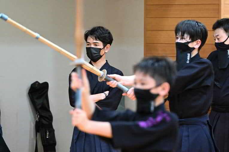 竹刀を持っての稽古を見守る戸崎総代表、一転して表情は真剣そのものに　©Keiji Ishikawa