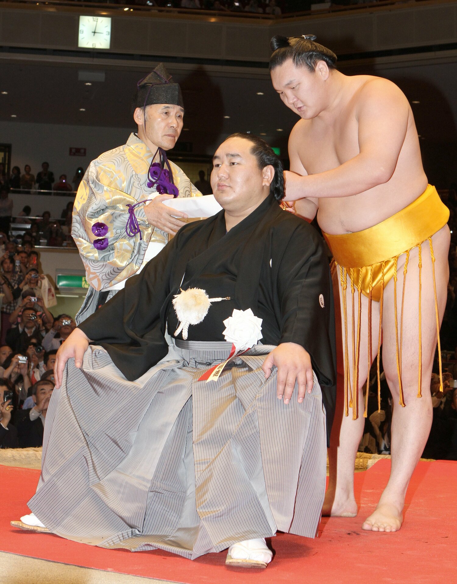 元横綱・朝青龍の断髪式でまげにはさみを入れる白鵬(2010年10月)©︎JIJI PRESS