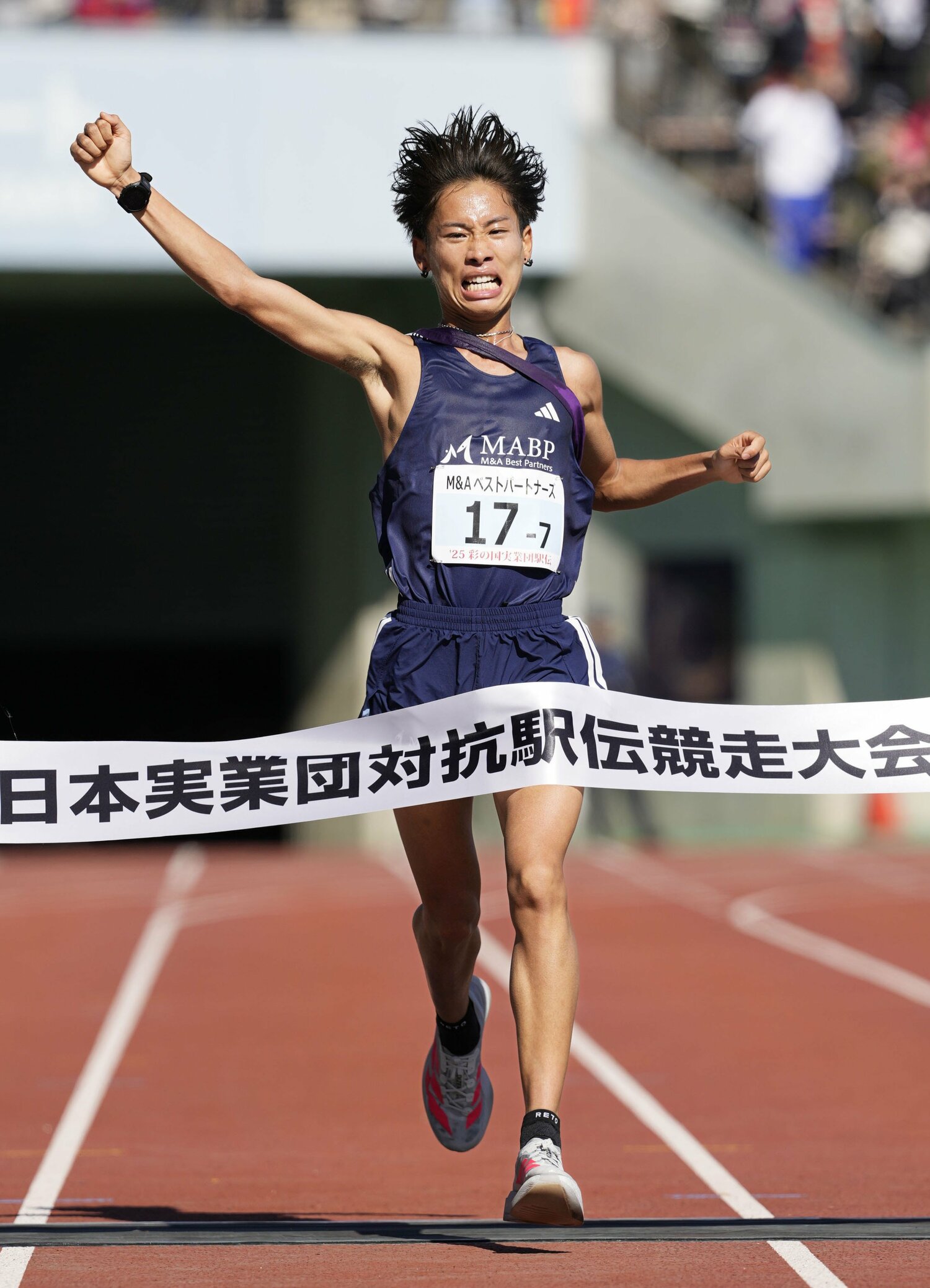 東日本実業団駅伝で予選突破のゴールテープを切り、中川は腕を突き上げた　©KYODO