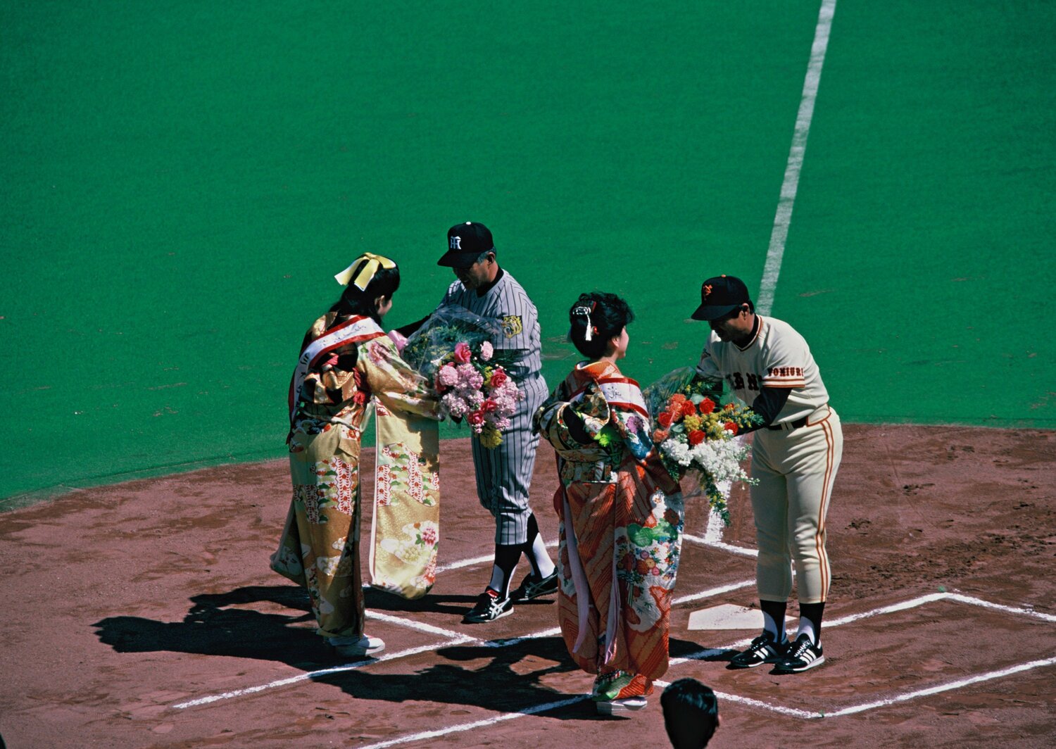 1984年のセ・リーグ開幕戦。花束を手渡される阪神の安藤統男監督と巨人の王貞治監督　©BUNGEISHUNJU
