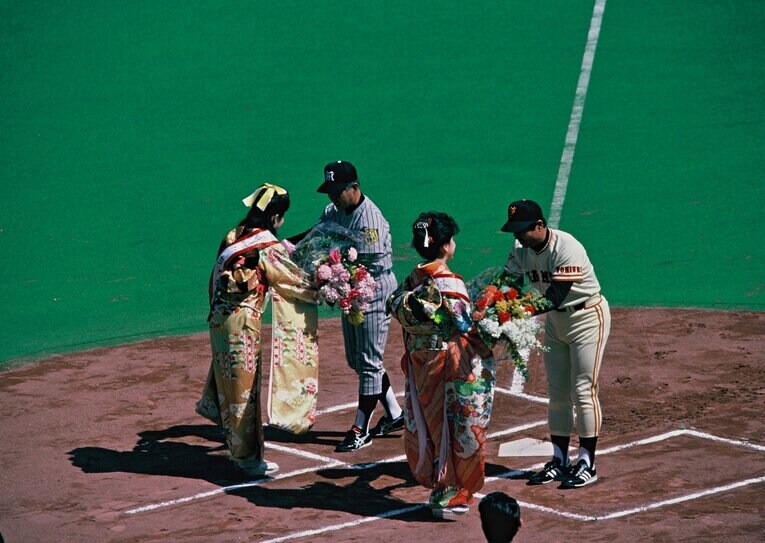1984年のセ・リーグ開幕戦。花束を手渡される阪神の安藤統男監督と巨人の王貞治監督　©BUNGEISHUNJU