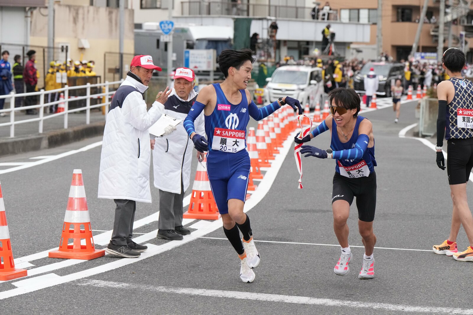 2年時に同級生・吉岡(左)から襷を受けて8区を走っている photograph by JMPA