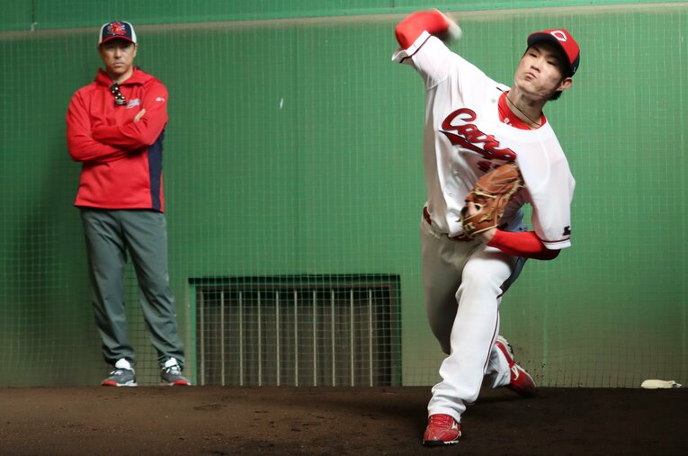 昨年の入団直後のキャンプで、黒田博樹球団アドバイザーが見守る中、投球練習する斉藤 ／ photograph by JIJI PRESS