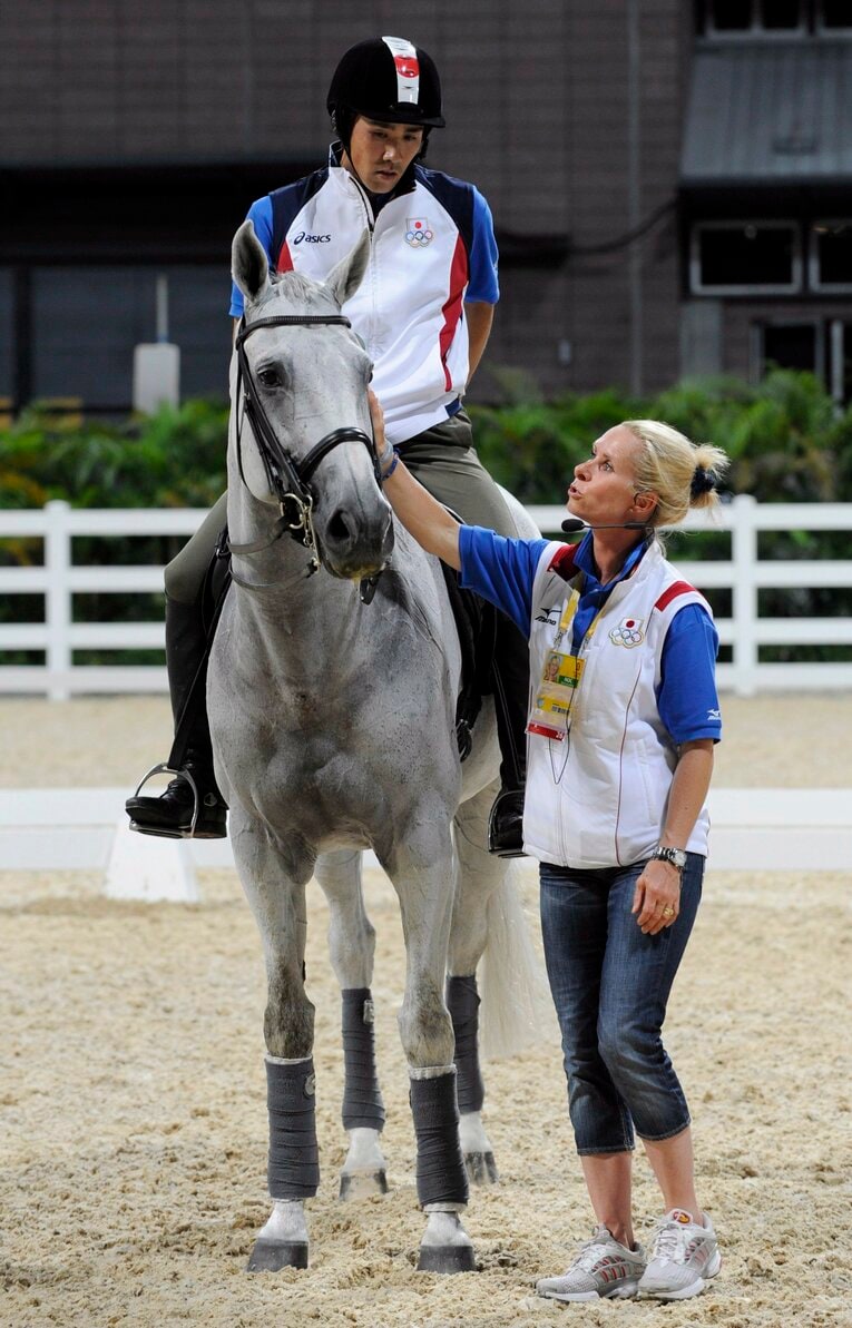 五輪初出場となった北京五輪の馬術練習場で「ゴージャス・ジョージ」号と。コーチのベッティーナ・ホイ（右）はアンドルー・ホイと夫婦（当時）で二人とも世界的なライダーである。ちなみに大岩の夫人、武田麗子もロンドン、リオに出場した馬術選手　©JIJI PRESS