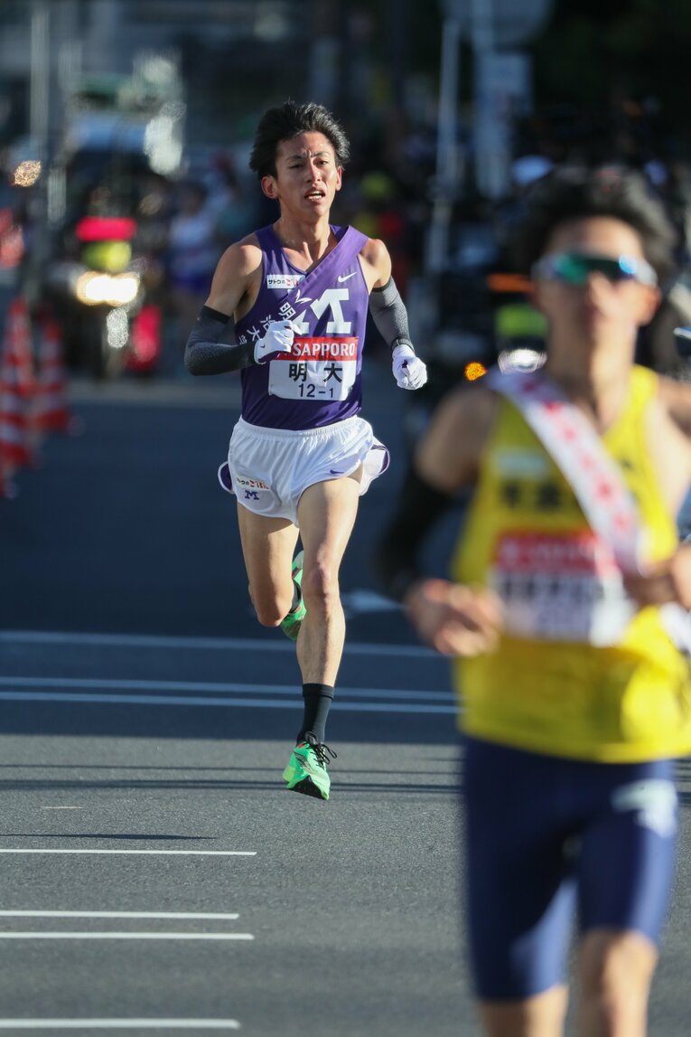 独走状態の新田に明大の富田が迫る　©JMPA