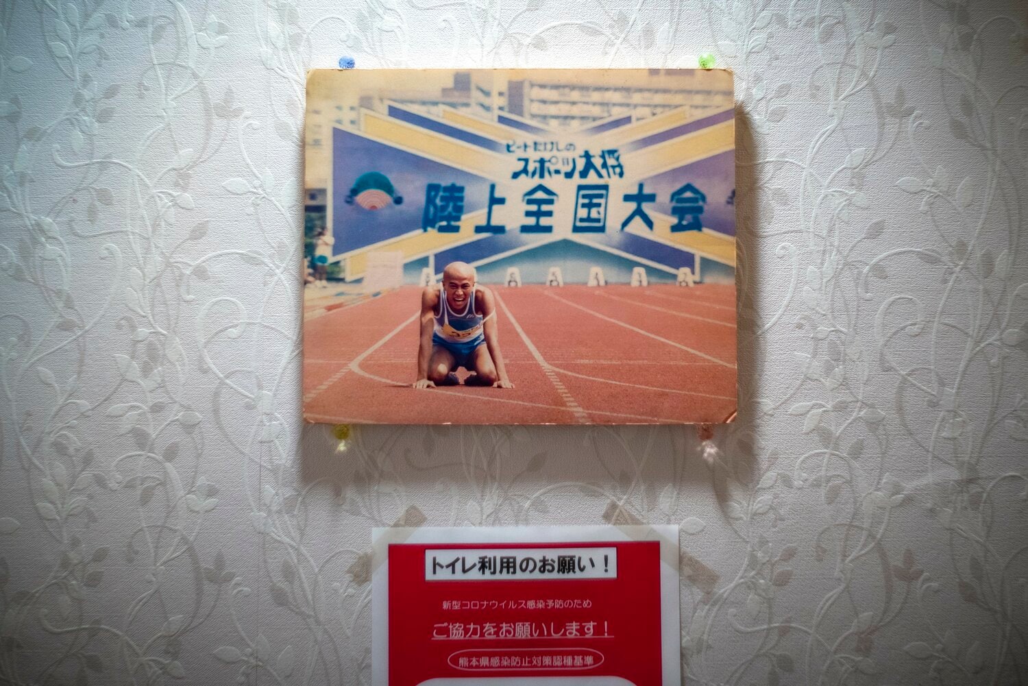 自身で切り盛りしているカラオケスナックのトイレにも『スポーツ大将』の写真がある　©Takuya Sugiyama