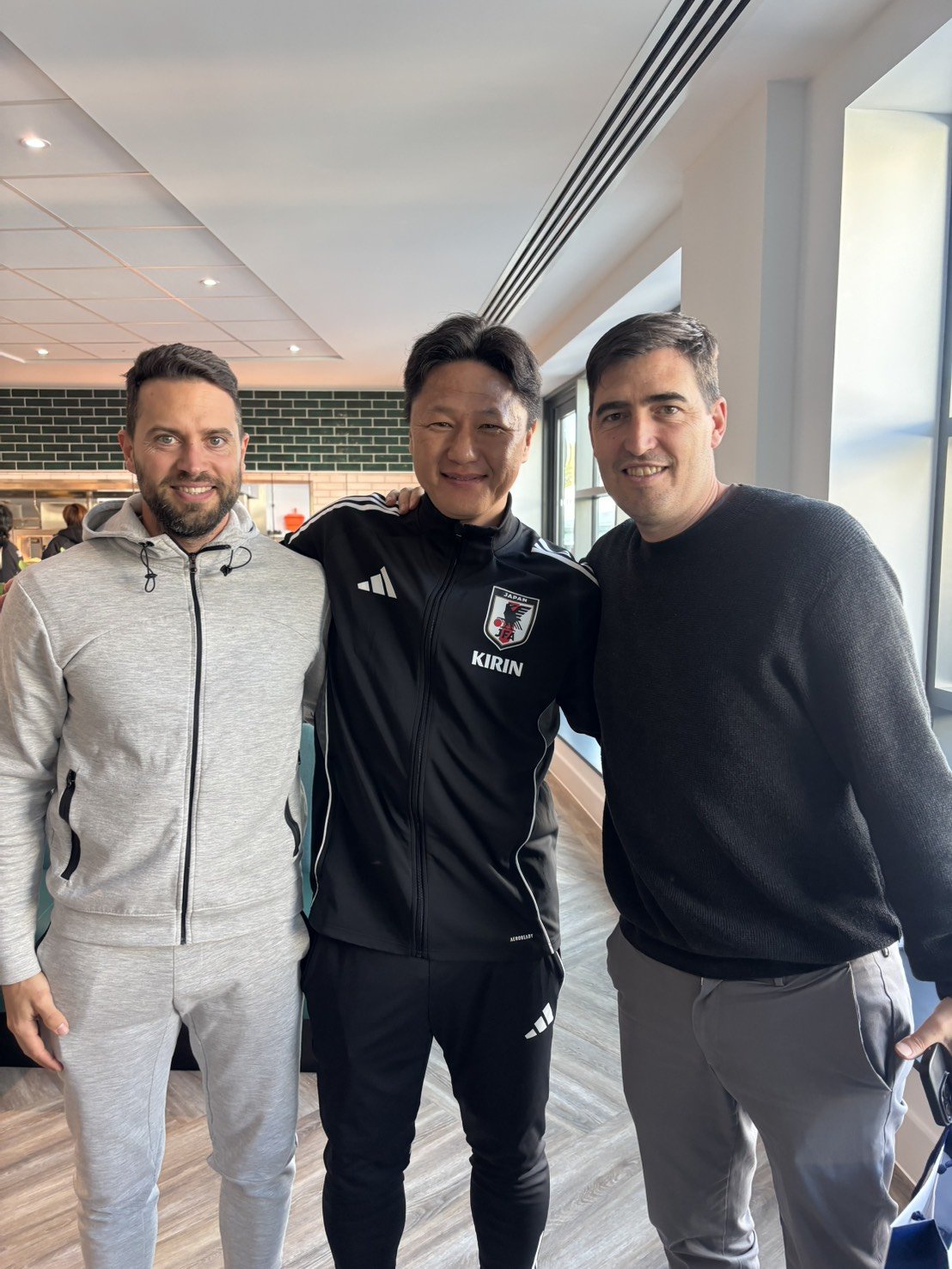 仲良く写真に収まるU‐22代表の大岩剛監督（中央）とボーンマスのイラオラ監督（右）　©JFA