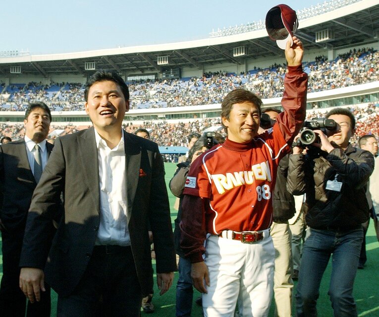 写真は開幕戦勝利後。笑顔で観客にあいさつする三木谷浩史オーナーと田尾監督　©JIJI PRESS