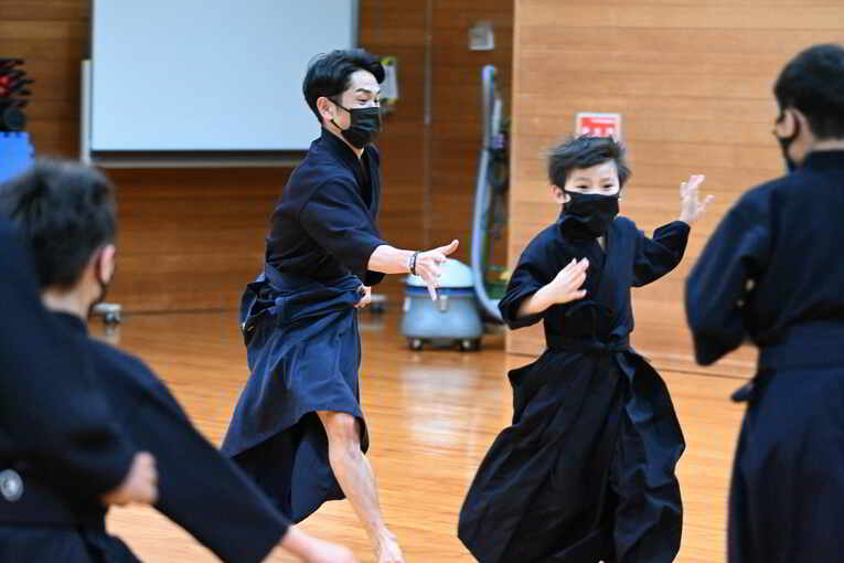 子どもたちと一緒に真剣に取り組む戸崎総代表　©Keiji Ishikawa