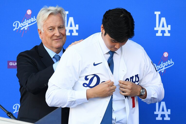 背中に手を当てるオーナー。大谷はボタンをかける作業に入る　©Getty Images