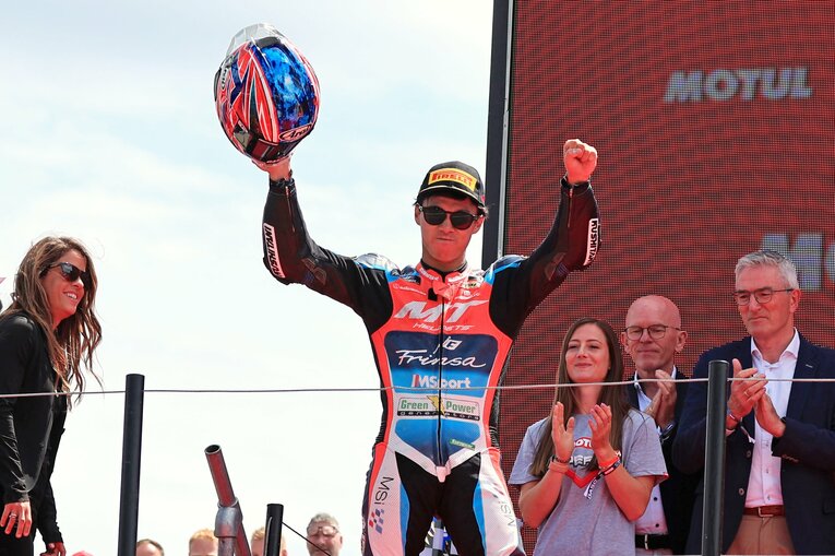 勝利したアッセンの表彰台でガッツポーズの小椋。右手にはこだわりのアライヘルメット　©Satoshi Endo