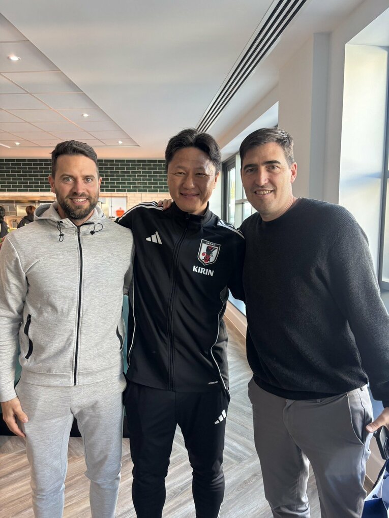 仲良く写真に収まるU‐22代表の大岩剛監督（中央）とボーンマスのイラオラ監督（右）　©JFA