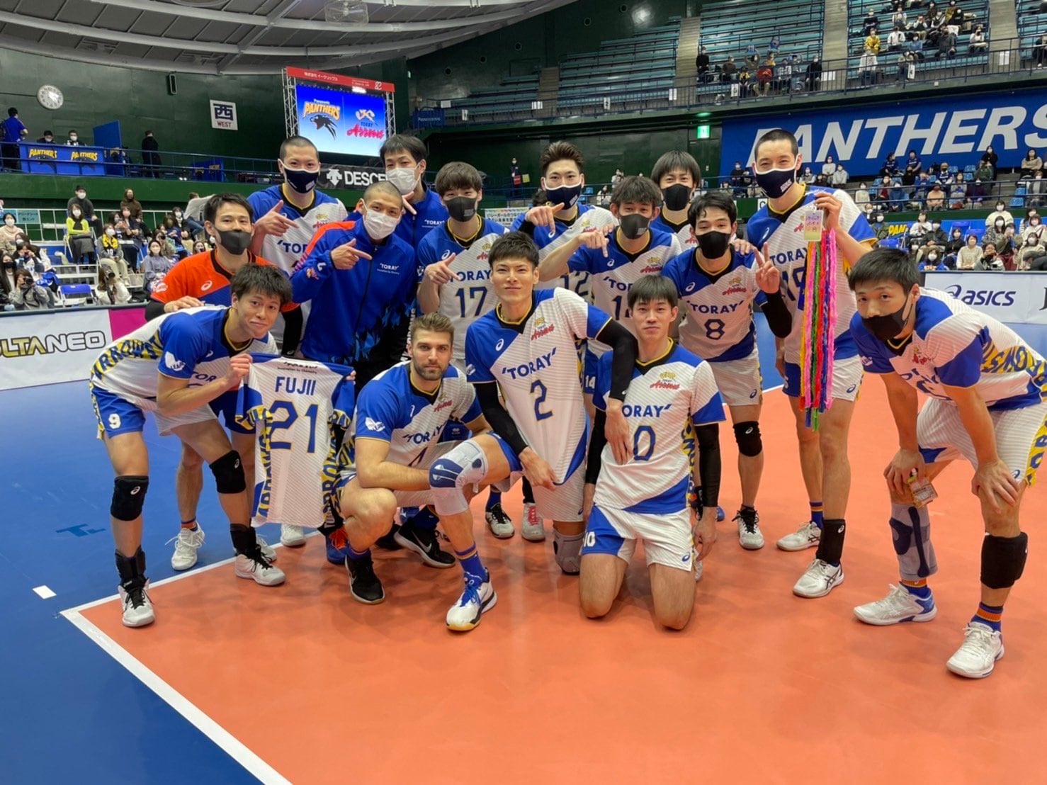 藤井のユニフォームと共に、今季リーグ20勝目を祝った東レのメンバー ©︎TORAY ARROWS