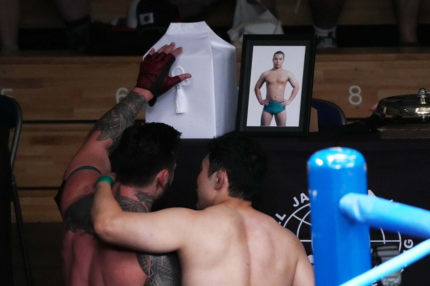 涙を流し、遺骨に手を添えるザイオン（左）と鈴木秀樹　©Essei Hara