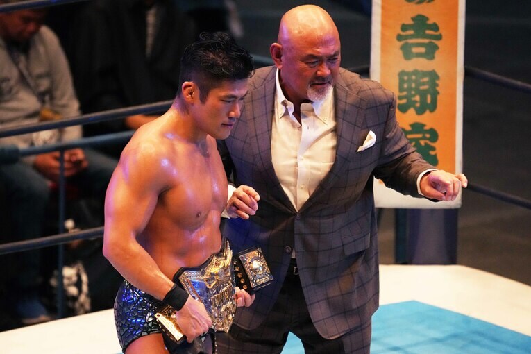 4度目のIWGP世界ヘビー級王座の防衛に成功したSANADAは武藤敬司からベルトを受け取る