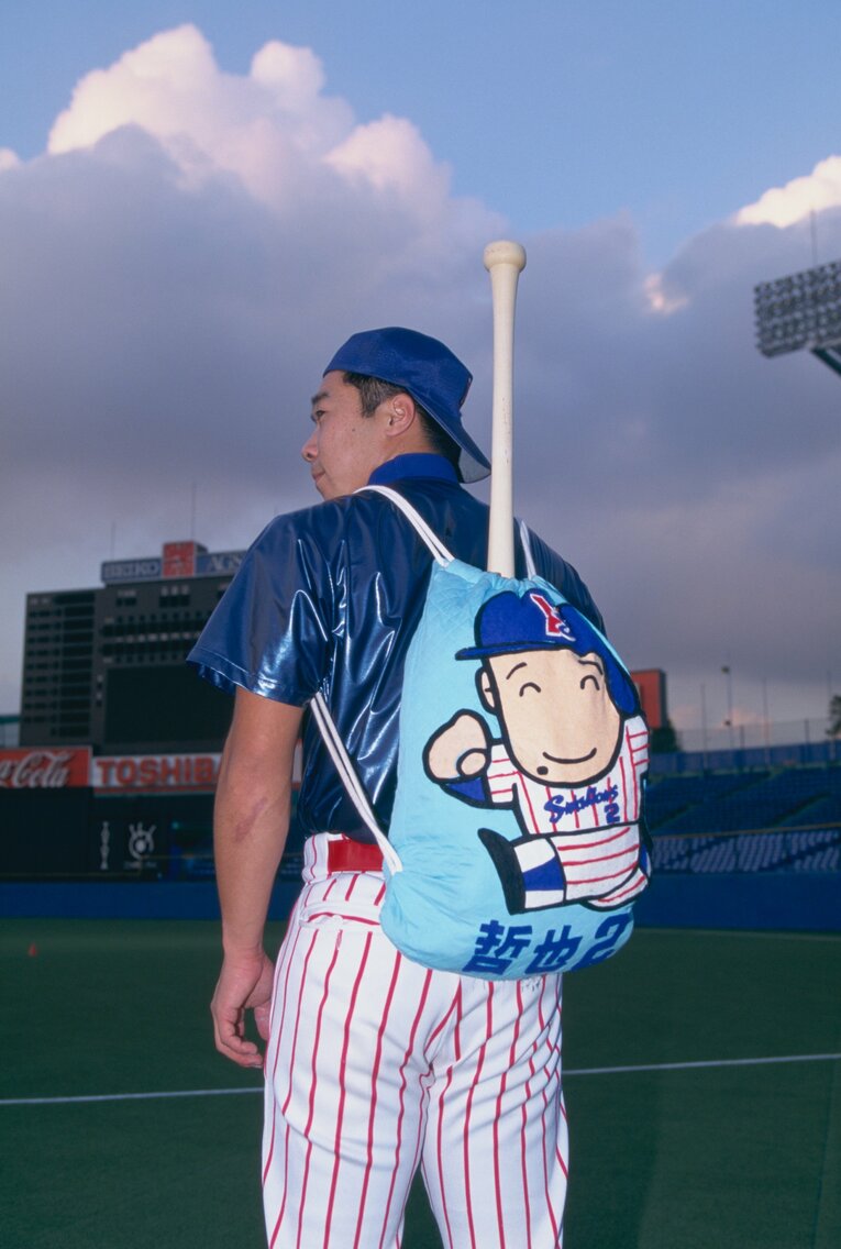 似顔絵付きのリュックを背負う飯田　©Shiro Miyake