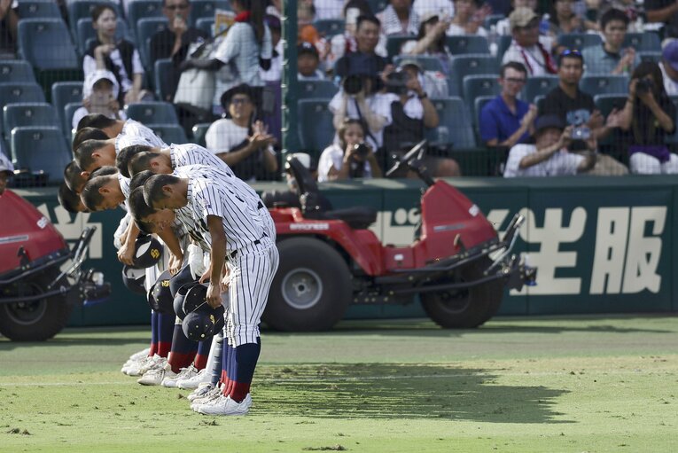 初戦で明徳義塾に敗れ、スタンドに頭を下げる鳥取城北ナイン　©KYODO