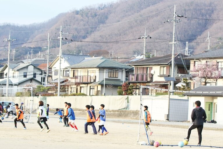 ボールを追いかける子どもたちを見守る市丸瑞希。引退後は指導者の道に進み、現在は小学生らにサッカーの魅力を教えている　©︎Takahito Ando