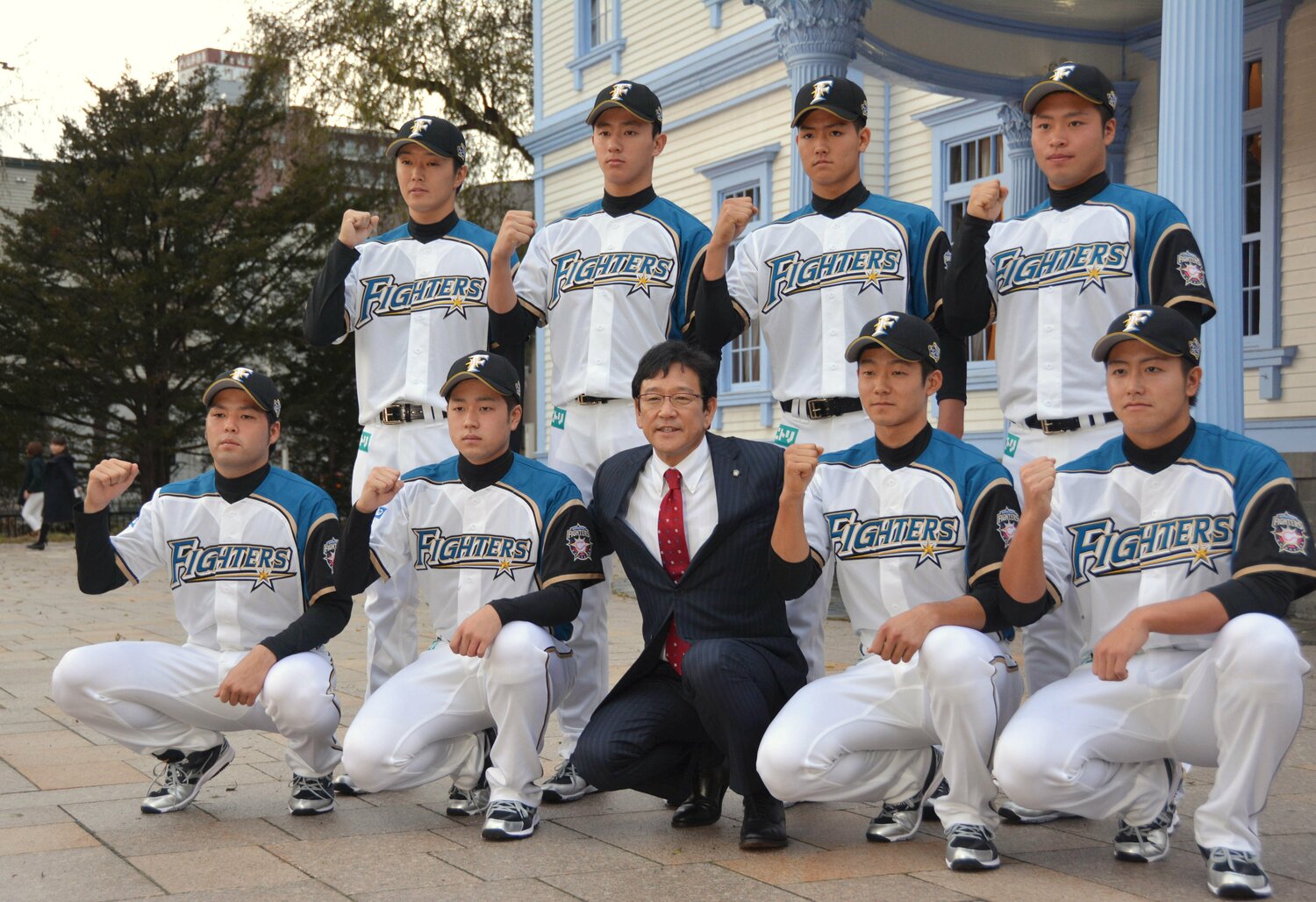2016年11月、日本ハムの新入団発表で栗山英樹監督と記念撮影するドラフト使命選手たち。石井は前列右から2人目 ©JIJI PRESS