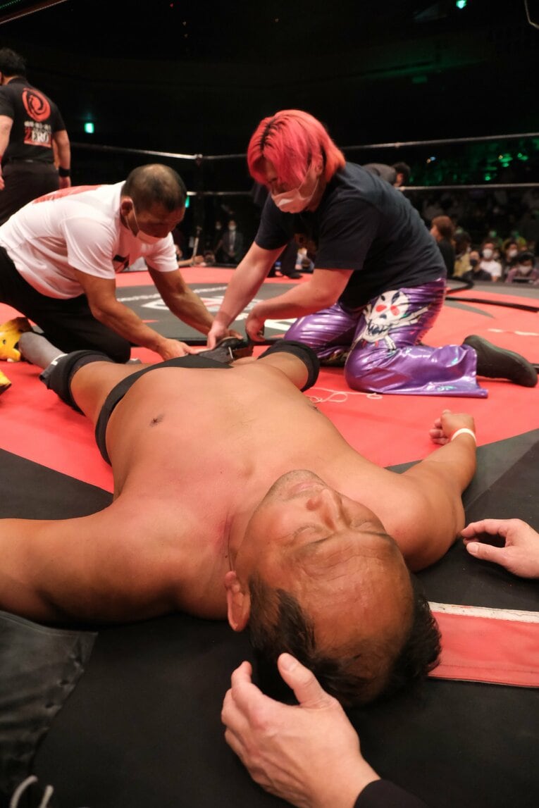 レフェリーストップで試合終了。救急隊を待つ間に選手たちが動けない大谷のリングシューズを脱がせるなどの処置を進めた