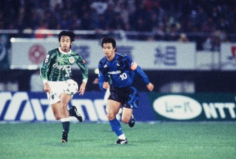 ガンバ大阪の礒貝洋光（右）と競り合う石塚（1994年のJリーグで）　©J.LEAGUE